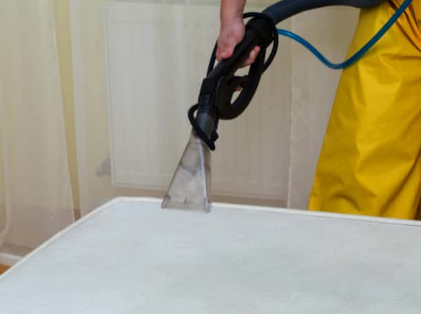 This is a photo of a man steam cleaning a dirty mattress works carried out by Belsize Park Carpet Cleaning Solutions