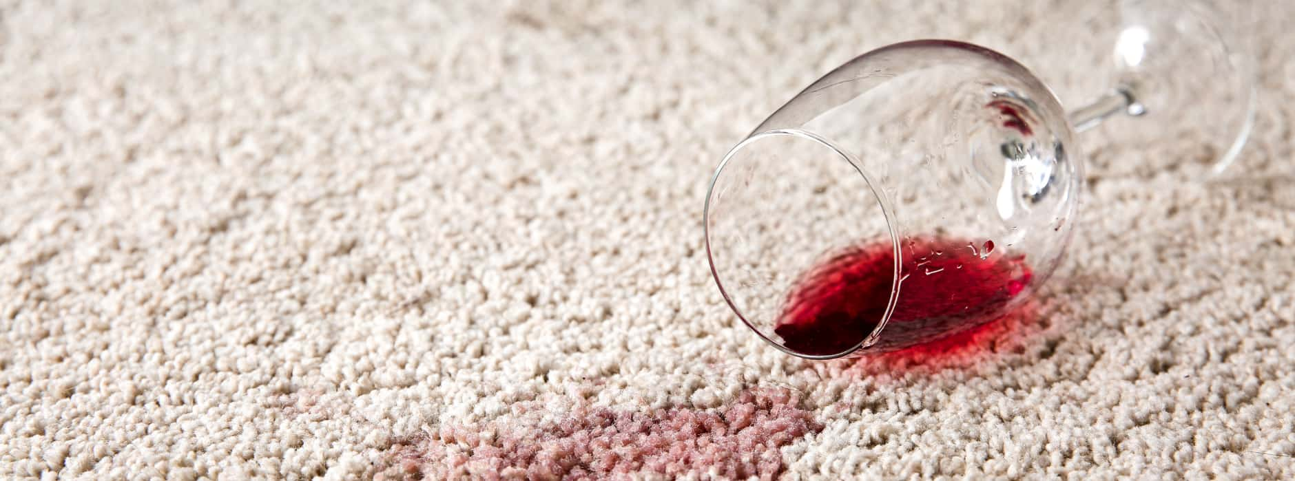 This is a photo of Belsize Park Carpet Cleaning Solutions red wine which has been spilt on a cream carpet. The glass is on its side